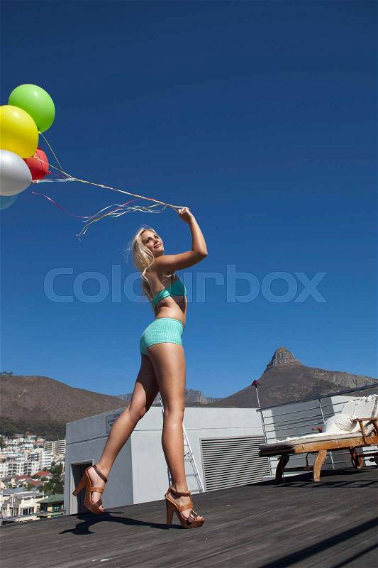 Woman in swimsuit with bunch of balloons, stock photo