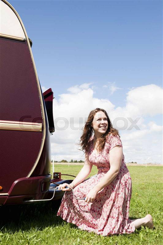 Woman working on trailer in field, stock photo