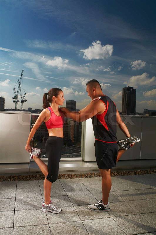 Athletes exercising together on rooftop, stock photo