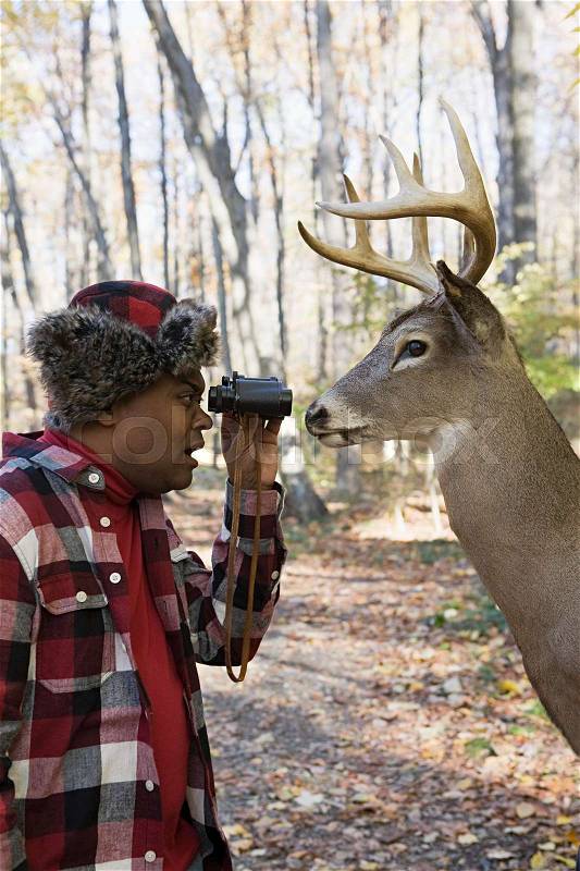 Hunter face to face with a deer, stock photo