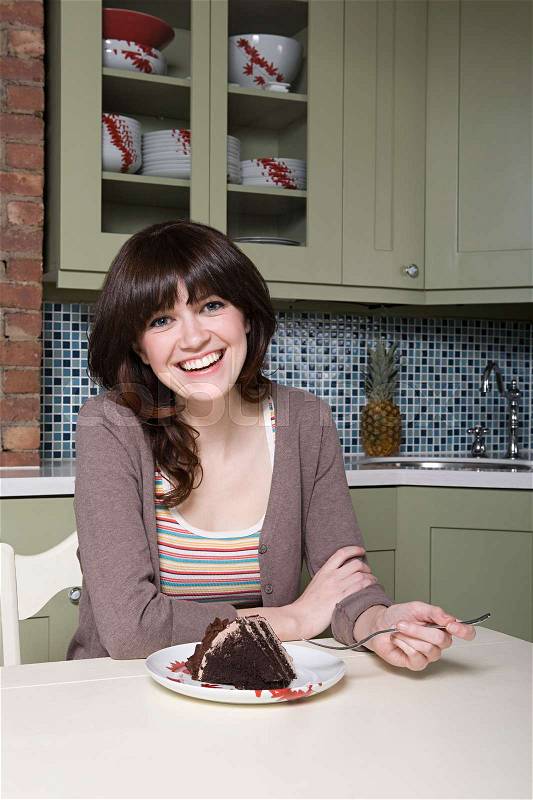 Young woman eating chocolate cake, stock photo