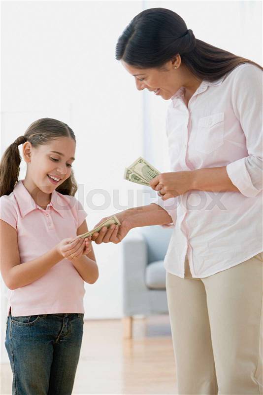 Mother giving daughter pocket money, stock photo