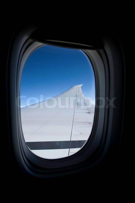 Airplane wing seen from inside commercial jet, stock photo