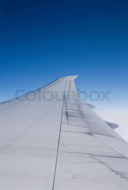 Airplane wing seen from inside commercial jet, stock photo