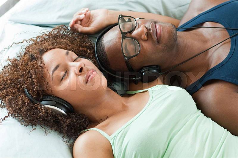 Man and woman listening to music, eyes closed, stock photo