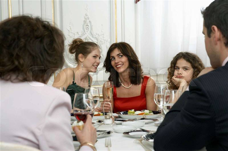 Two women talking at dinner table, stock photo