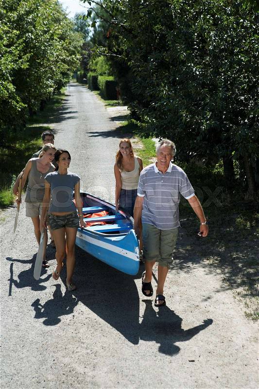 People on a path carrying a canoe, stock photo