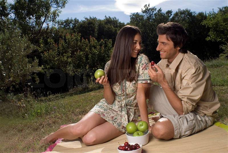 Young couple sharing fresh fruit, stock photo