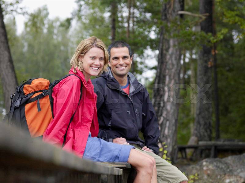 Couple sitting on a dock smiling, stock photo