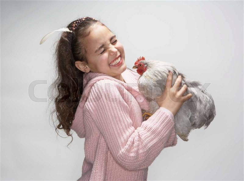 Girl laughing at hen, stock photo