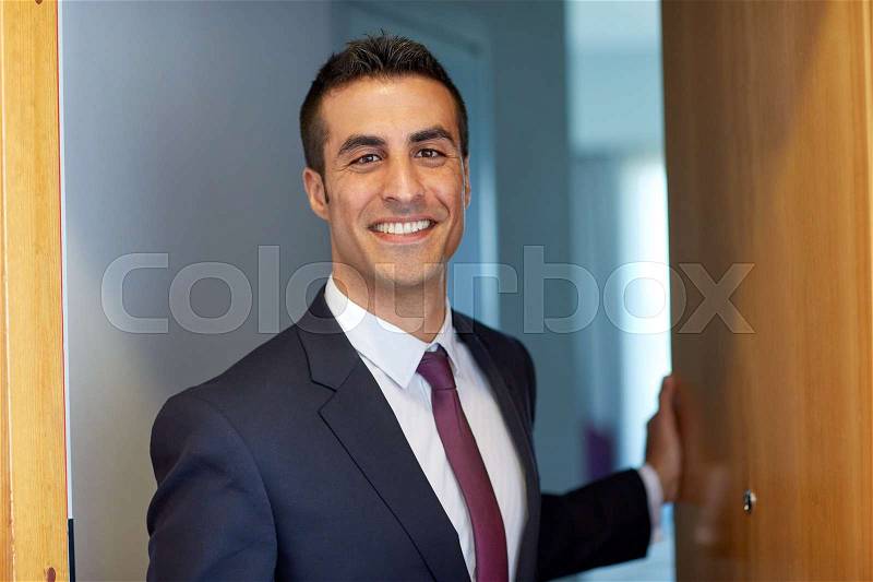 Business and people concept - businessman at hotel room or office door, stock photo