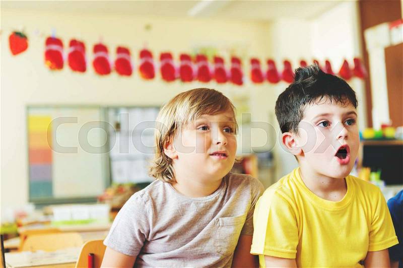 Two concentrated 4-5 year old boys in classroom, stock photo
