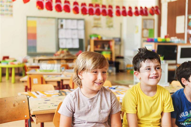 Two concentrated 4-5 year old boys in classroom, stock photo