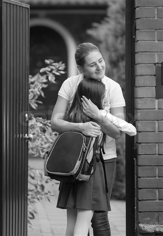 Monochrome photo of happy mother and daughter meeting after school, stock photo
