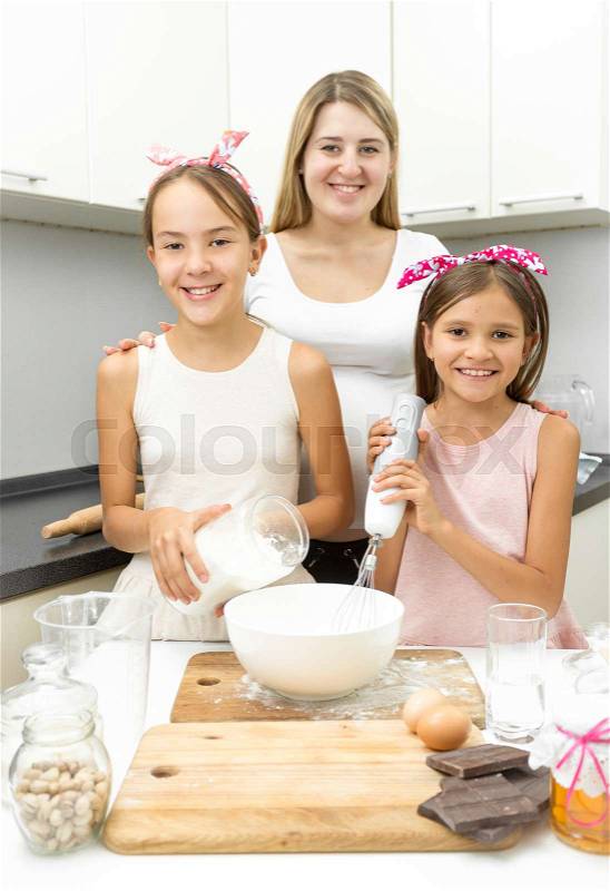 Portrait of happy smiling family making dough for pie on kitchen, stock photo