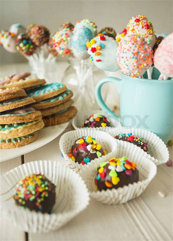 Photo of colorful cake pops and cookies with icing, stock photo