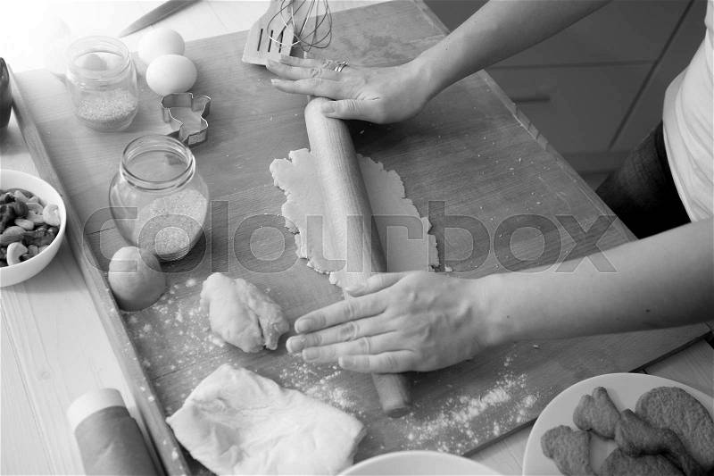 Black and white image of woman using rolling pin while cooking, stock photo