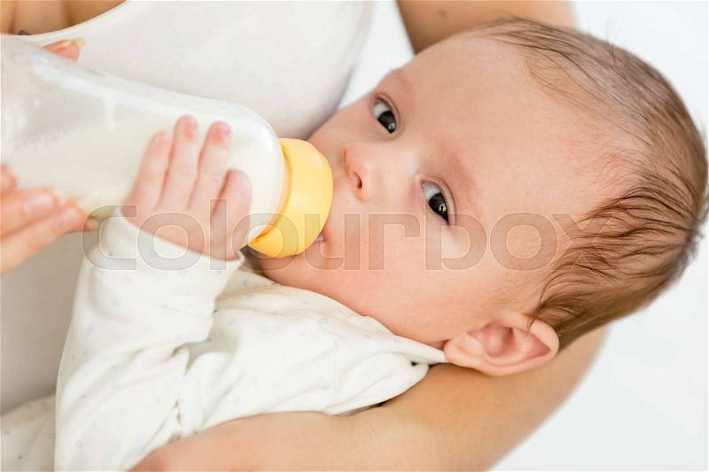 Mother feeding her 3 months old baby from bottle, stock photo