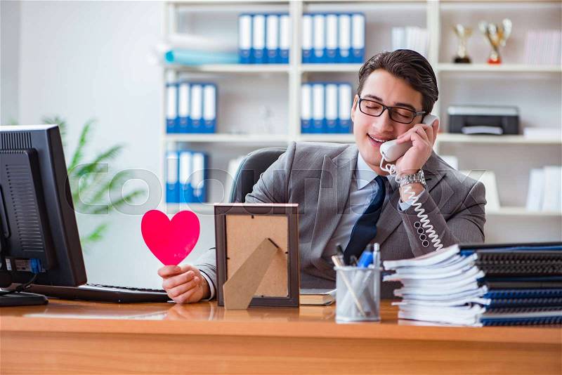 Businessman feeling love and loved in the office, stock photo