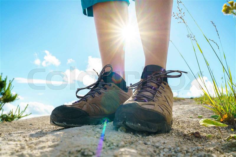 Legs of woman in tourist boots close-up. Hiking with a backpack over hilly terrain, stock photo