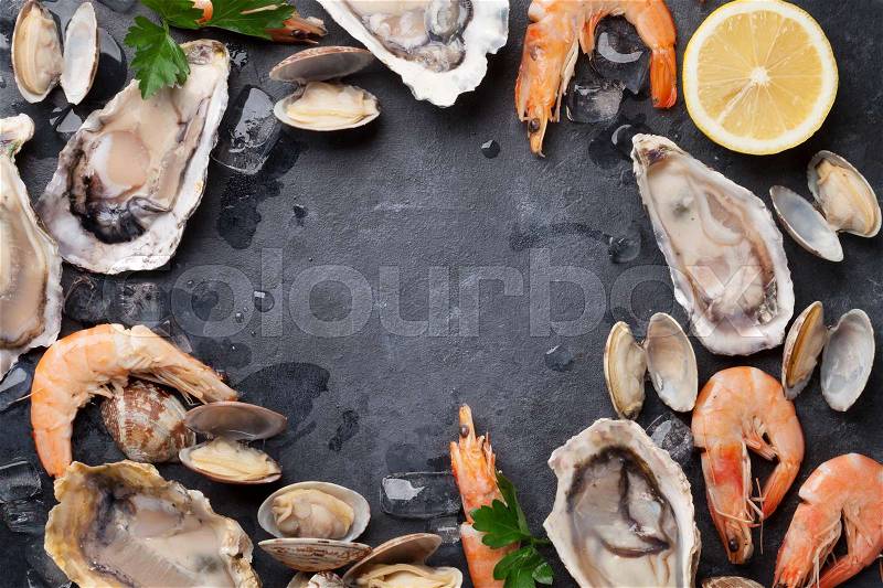 Fresh seafood on stone table. Oysters, prawns and scallops. Top view with copy space, stock photo