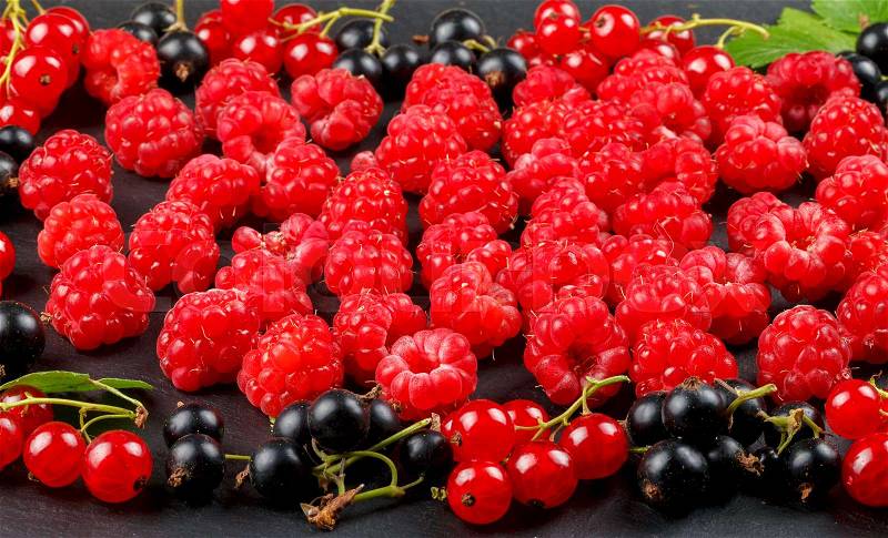 Fresh berries of cherry, raspberries, red currant and blackcurrant on a dark background, stock photo