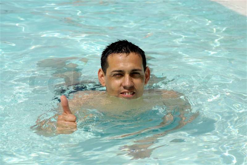 A happy man is making ok sign in pool, stock photo