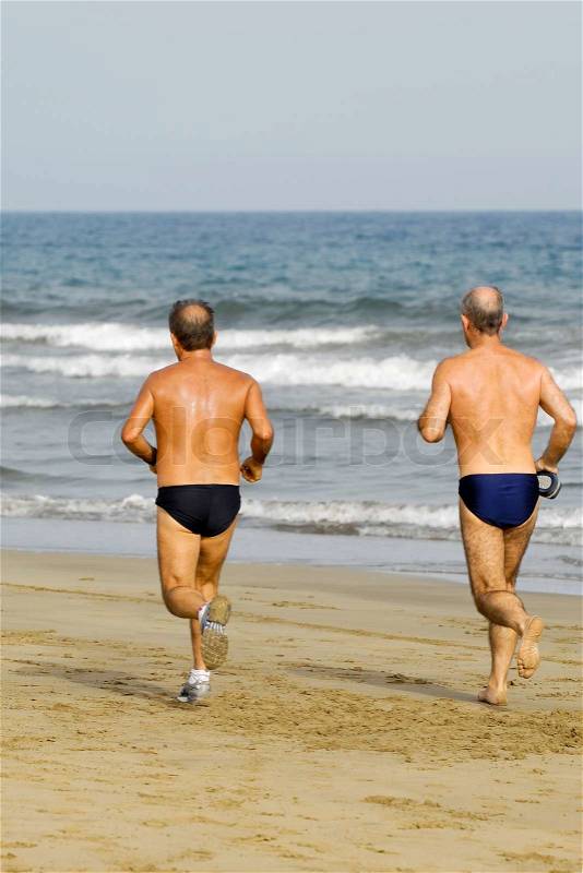 Old men is running on the beach, stock photo