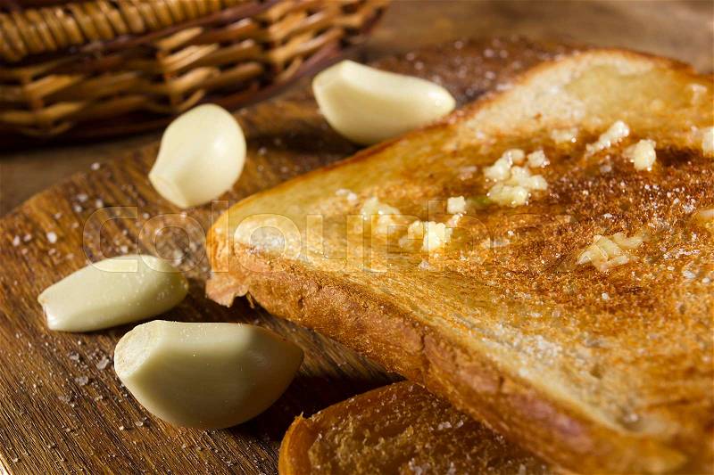 Roasted garlic bread close-up, and cloves of fresh garlic, stock photo