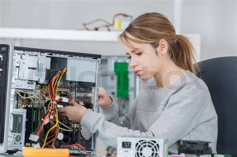 Tech tests electronic equipment in service centre, stock photo