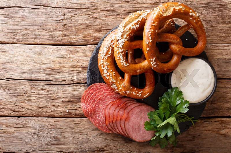 German food: sliced sausages and pretzels with cream sauce close-up on the table. horizontal view from above , stock photo