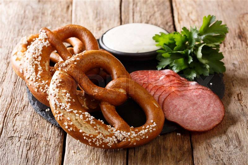 German food: sliced sausages and pretzels with cream sauce close-up on the table. Horizontal , stock photo