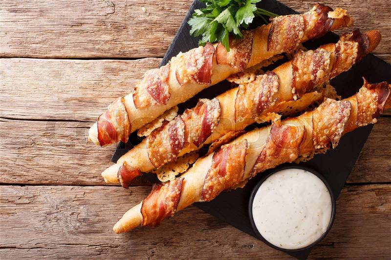 German sticks with bacon and cheese close-up on the table and garlic sauce. horizontal view from above , stock photo