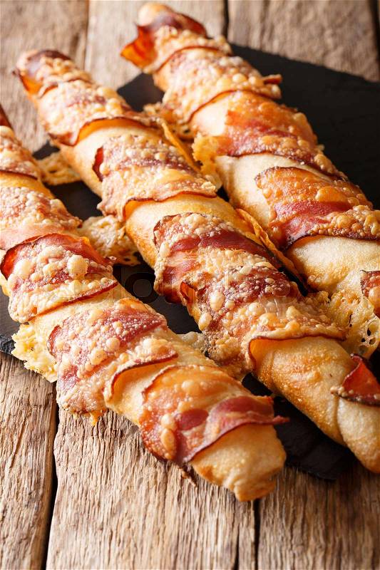 Homemade delicious bread sticks with bacon and cheese close-up on the table. vertical , stock photo