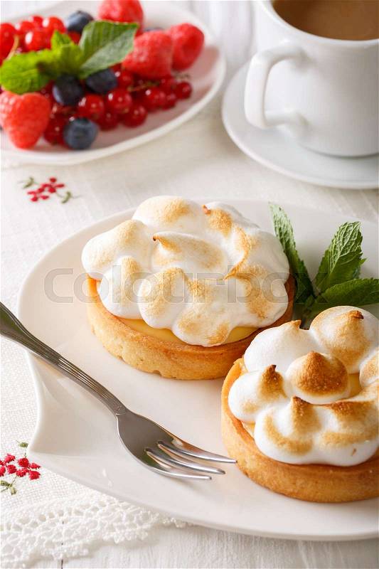 Beautiful food: lemon tart with meringue and coffee, berries close-up on the table. vertical , stock photo