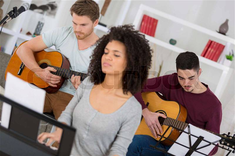 Group of young friends playing the guitar, stock photo