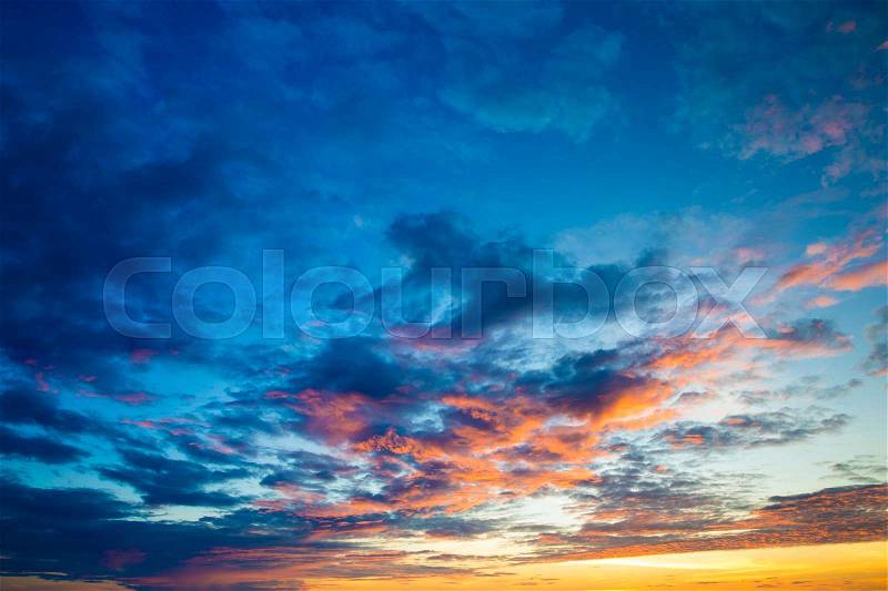 Blue and orange sunset sky with rays of sun. Natural landscape for background, stock photo