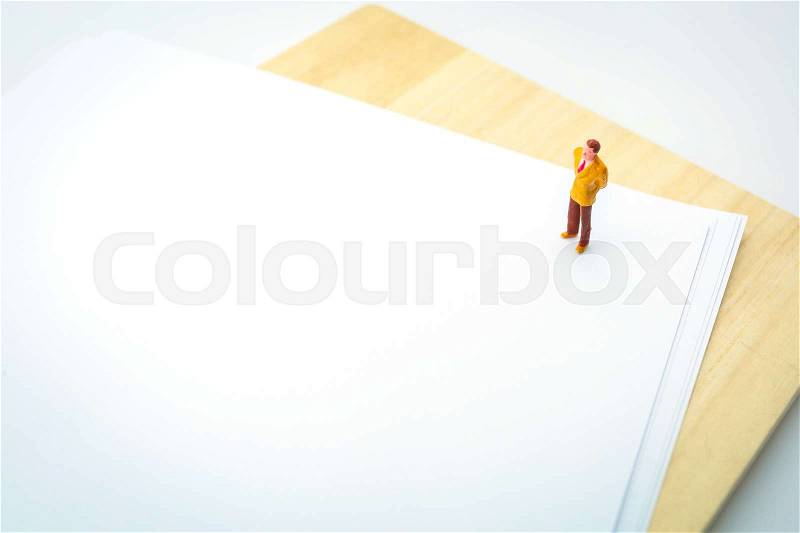 Miniature business man on white document paper, image for business background and working concept, stock photo