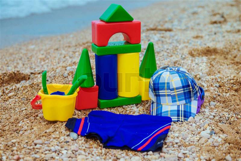 Children\'s toys and flip flops in the sand, stock photo