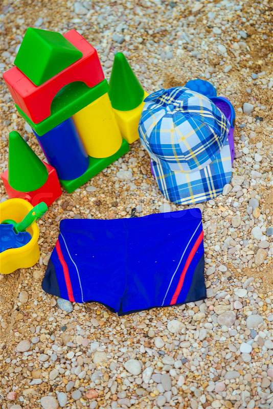Children\'s toys and flip flops in the sand, stock photo