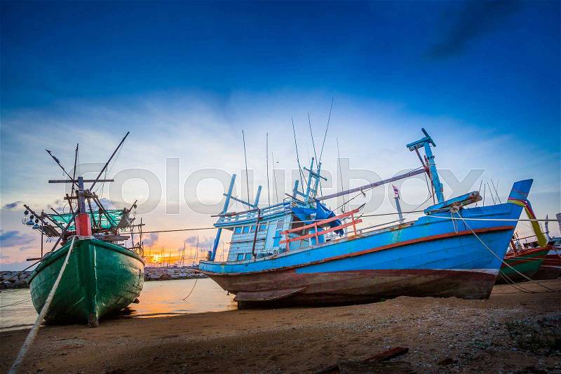 The twilight scene of wooden fishing boat floating at the seashore , Pattaya Thailand, stock photo