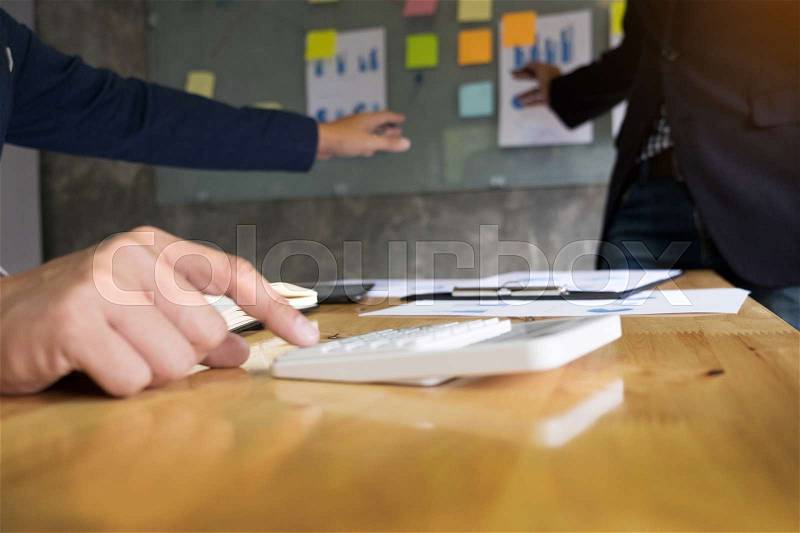 Business man financial inspector and secretary making report, calculating or checking balance. Internal Revenue Service inspector checking document. Audit concept at working with plan on office desk and modern digital tablet, stock photo