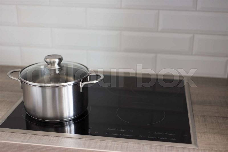 Metal pot on electric stove in modern kitchen, stock photo