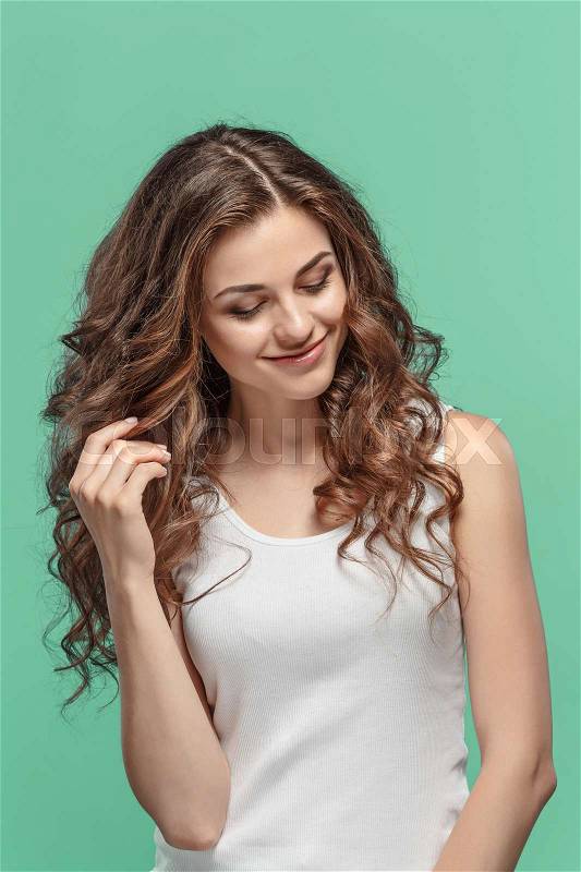 The young woman\'s portrait with happy emotions on gray background, stock photo