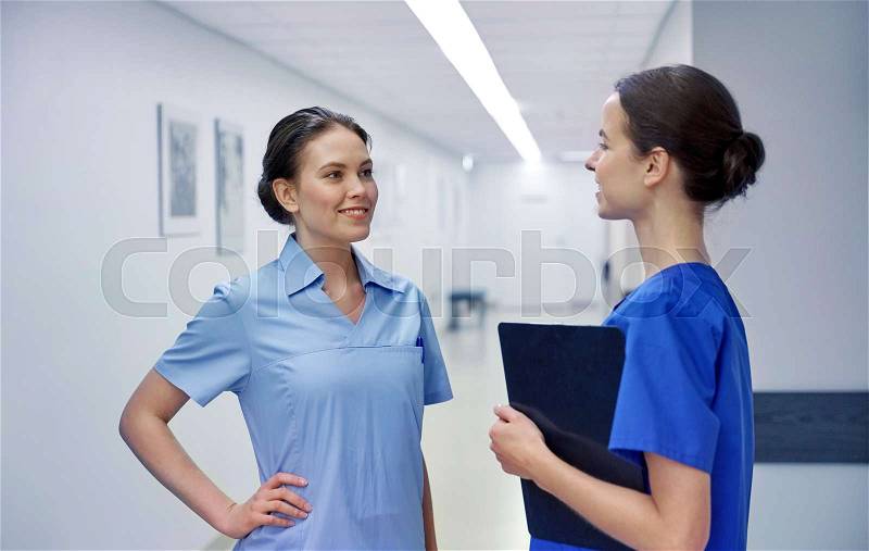 Clinic, profession, people, health care and medicine concept - nurses or doctors talking at hospital, stock photo