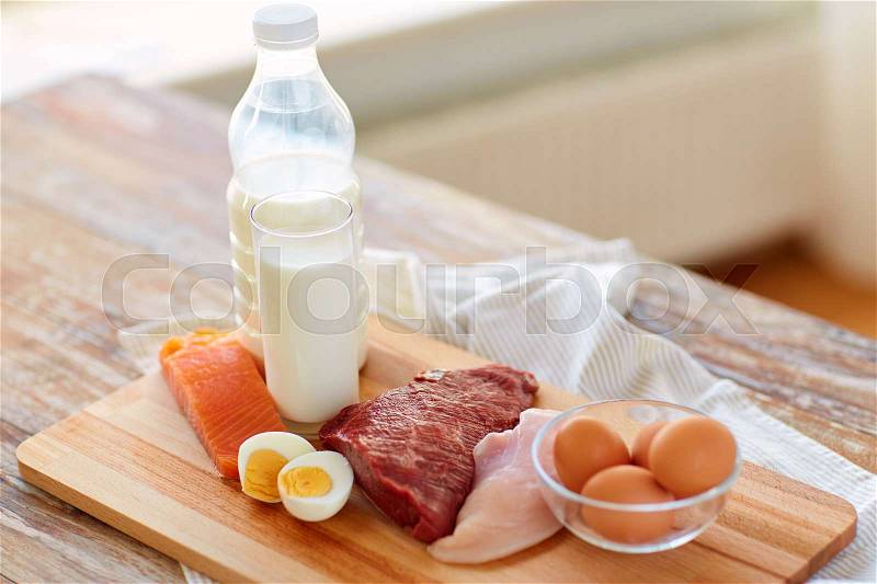 Natural food, healthy eating and protein diet concept - raw meat fillet, fish, milk and eggs on wooden table, stock photo