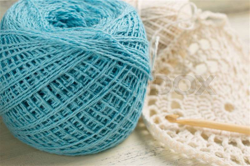 Yarn for crochet and knitted openwork napkins on shabby wooden board, stock photo