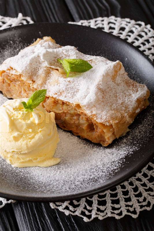 Delicious apple strudel with sugar powder, ice cream and mint closeup on a plate. vertical , stock photo