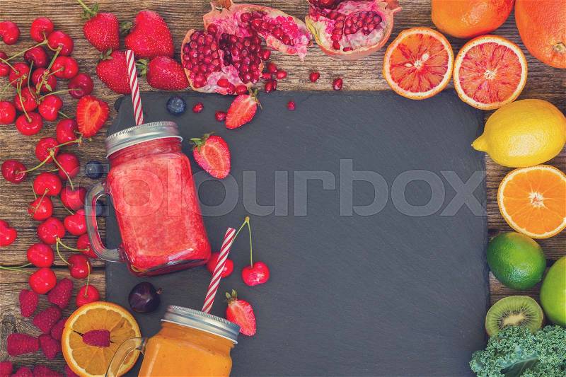 Fresh smoothie citrus and berry drinks with igredients, copy space on black stone, retro toned, stock photo
