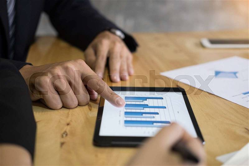 Business man financial inspector and secretary making report, calculating or checking balance. Internal Revenue Service inspector checking document. Audit concept at working with plan on office desk and modern digital tablet, stock photo
